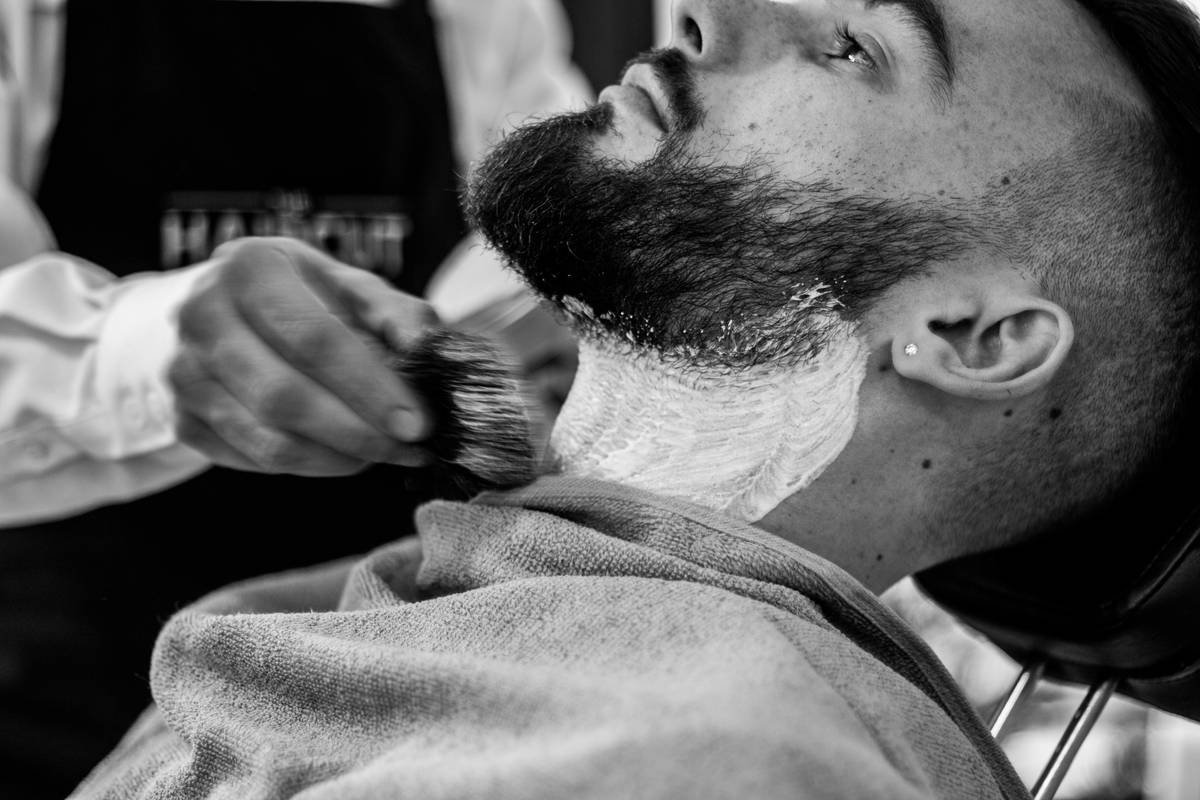 Infographic showing how friction between plastic comb and dry beard hair creates static electricity, with humidity levels and material types labeled
