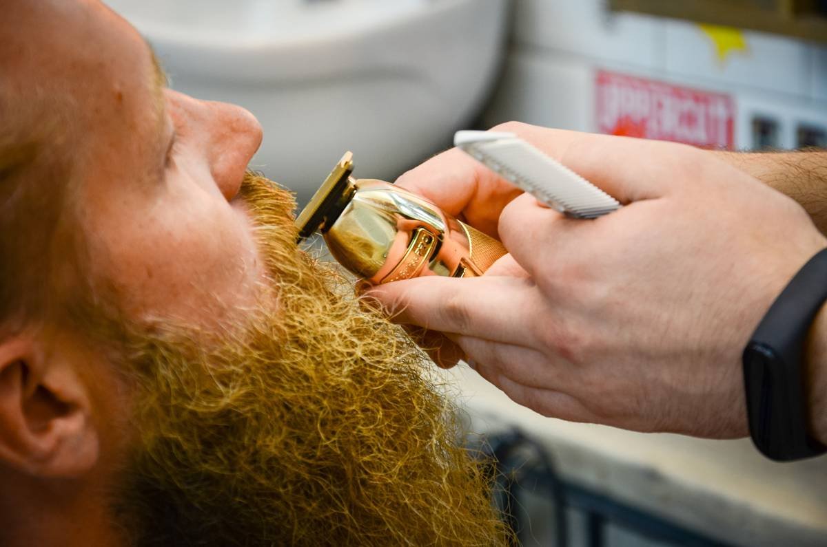 Side-by-side comparison of plastic, cellulose acetate, and sandalwood beard combs showing tooth finish and flexibility