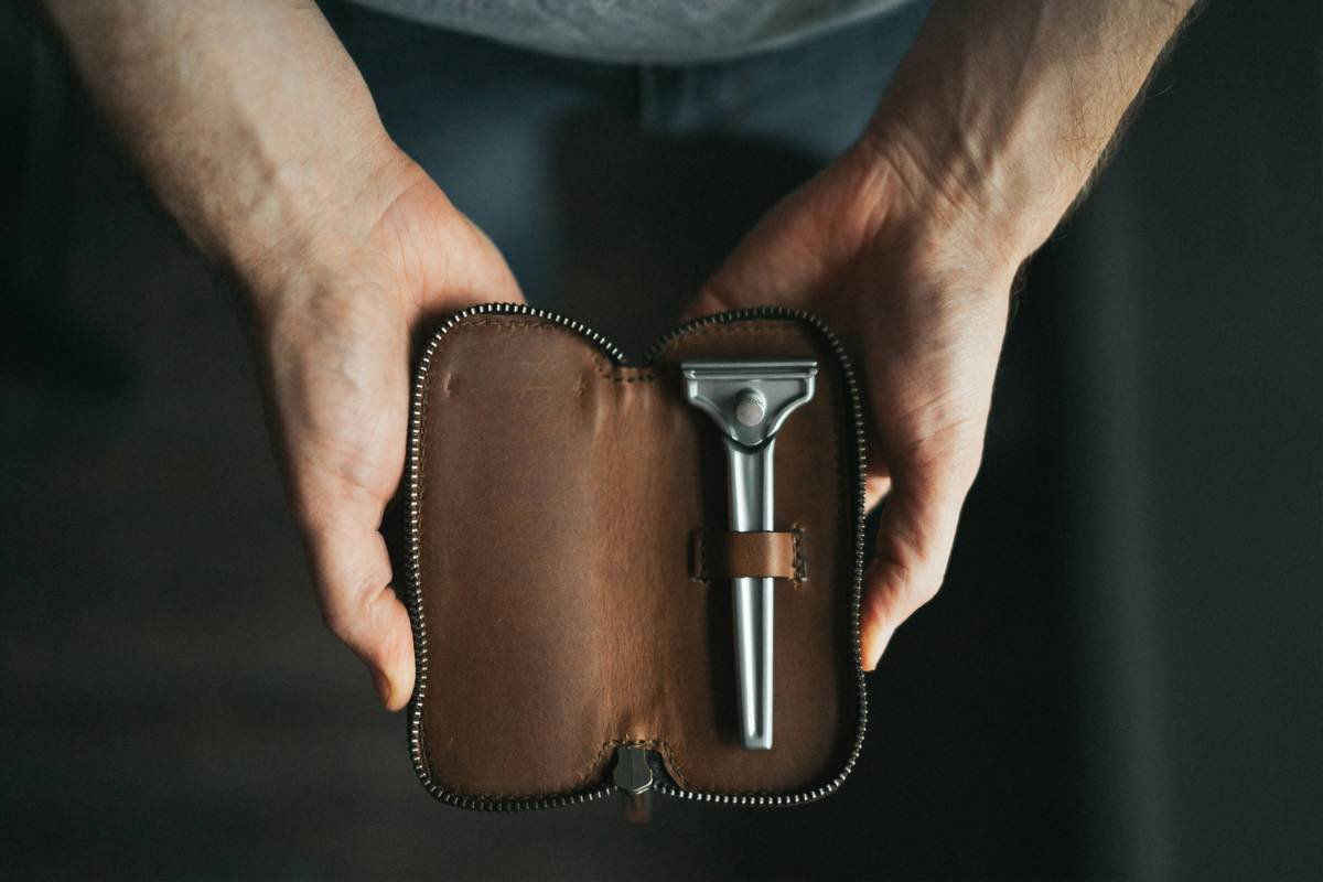 Premium beard comb with comb case resting on a leather travel kit
