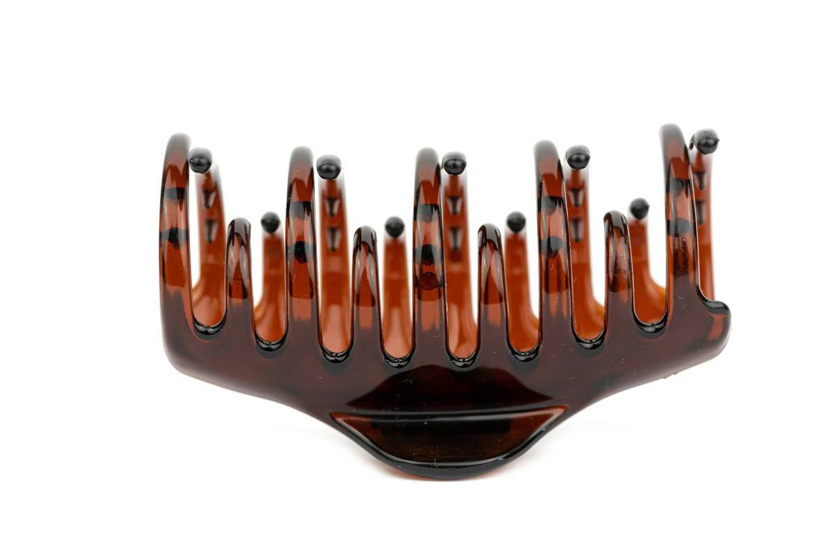 Man using comb for distributing beard oil evenly across full beard