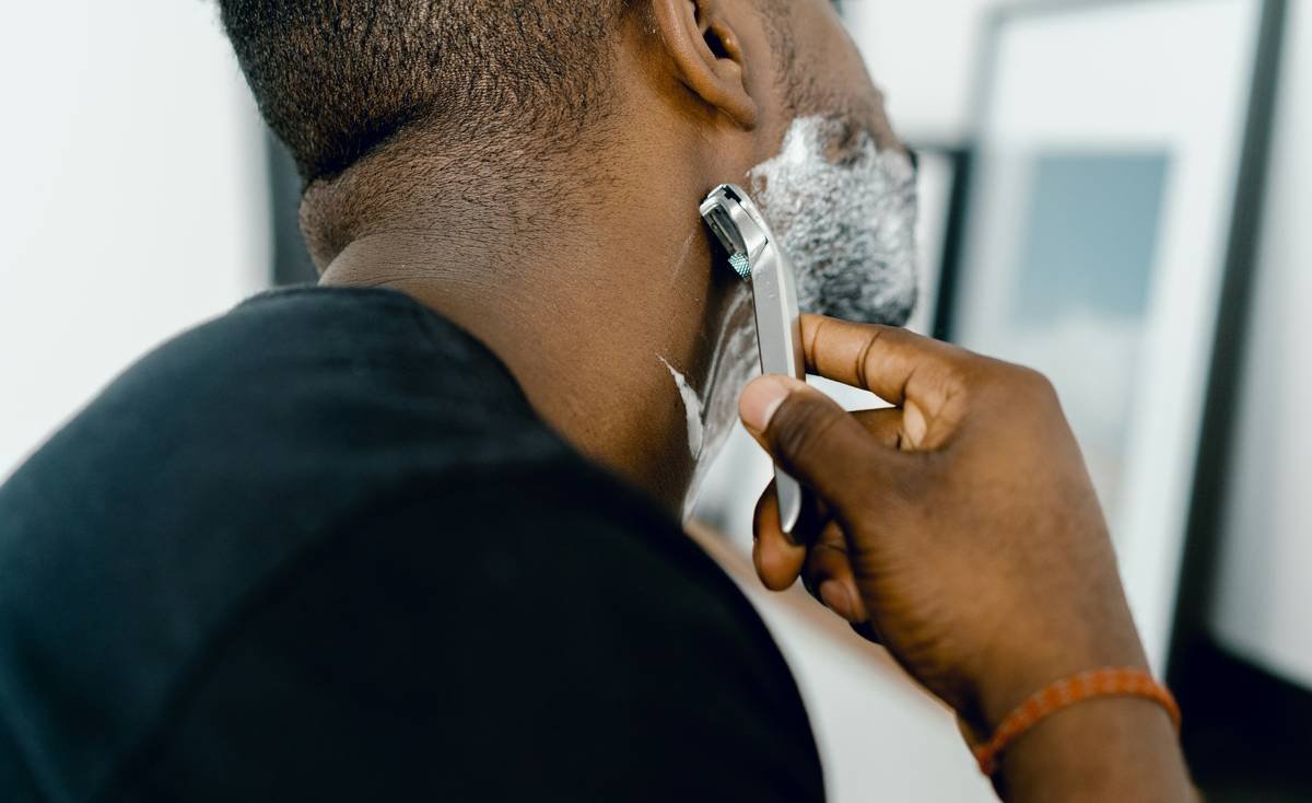 Side-by-side comparison showing how a curved beard comb aligns with jawline curvature while a flat comb causes uneven tension and pulling